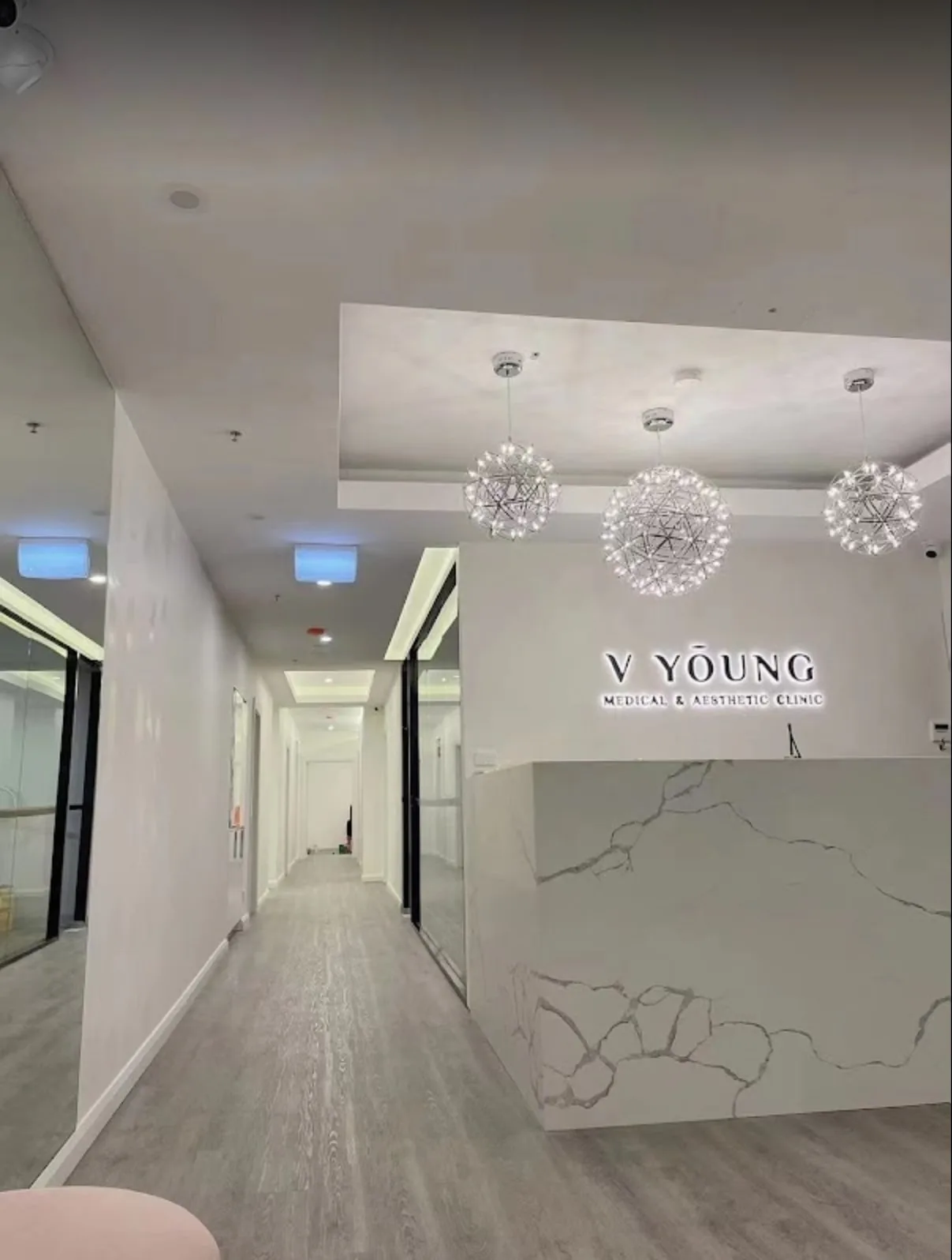 Reception corridor with three starburst chandeliers receding into the treatment suites