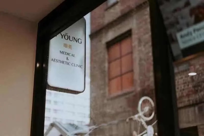 V Young 唯美 Medical and Aesthetic Clinic window sign at 16 Liverpool Street Melbourne against the reflected streetscape